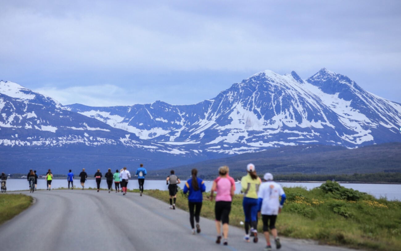 People running the  Midnight Sun Marathon with a mountainous backround.