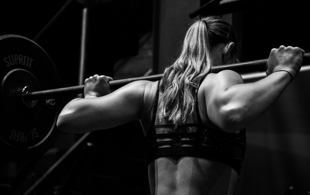 A person doing a back squat.