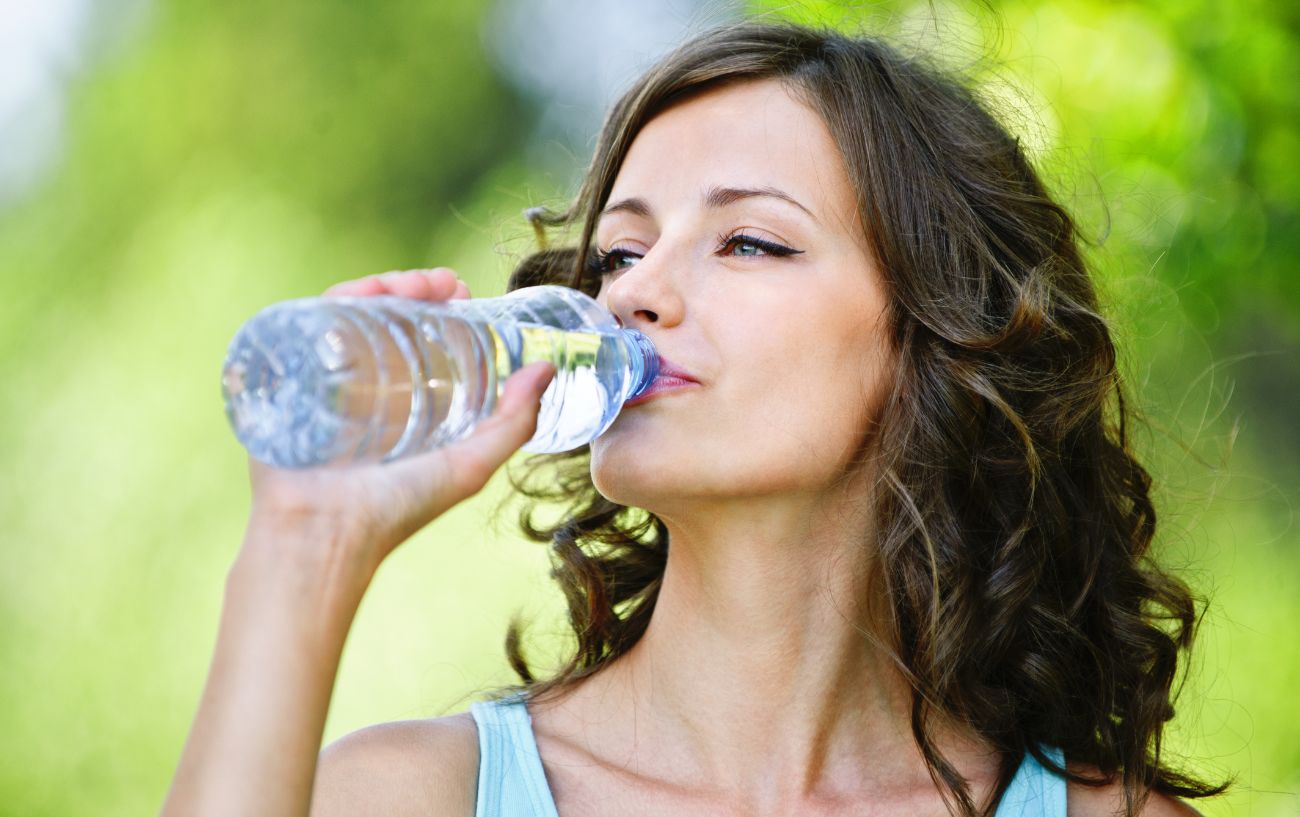 Una persona bebiendo de una botella de agua.