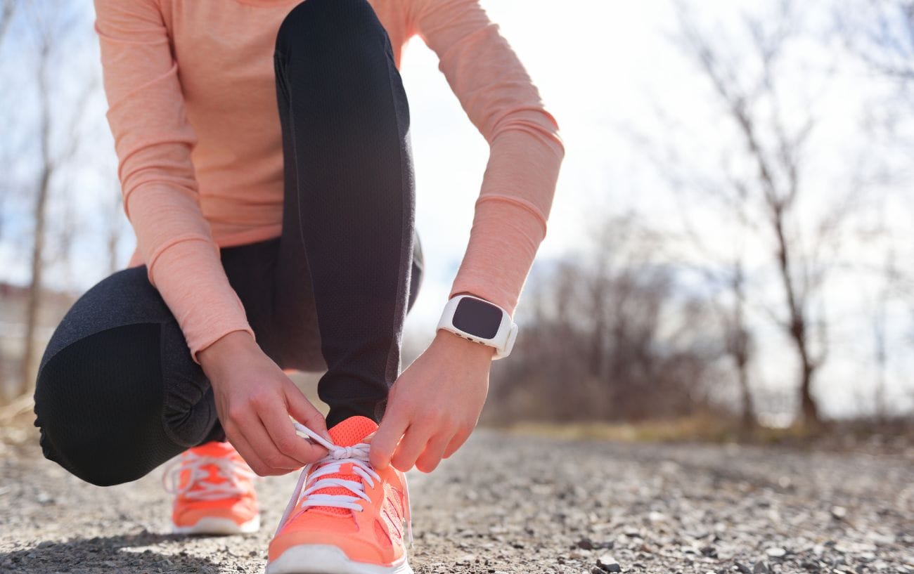 The 10% Rule: Is It a Valid Way to Increase Your Weekly Running Mileage? 3 a person tying shoelaces on a trail
