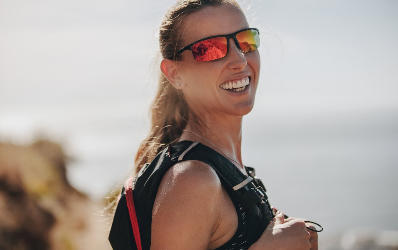 Why Running Feels So Good: The Secret Behind Runner’s Highs and Flow States 3 A runner with a pack and sunglasses smiling.