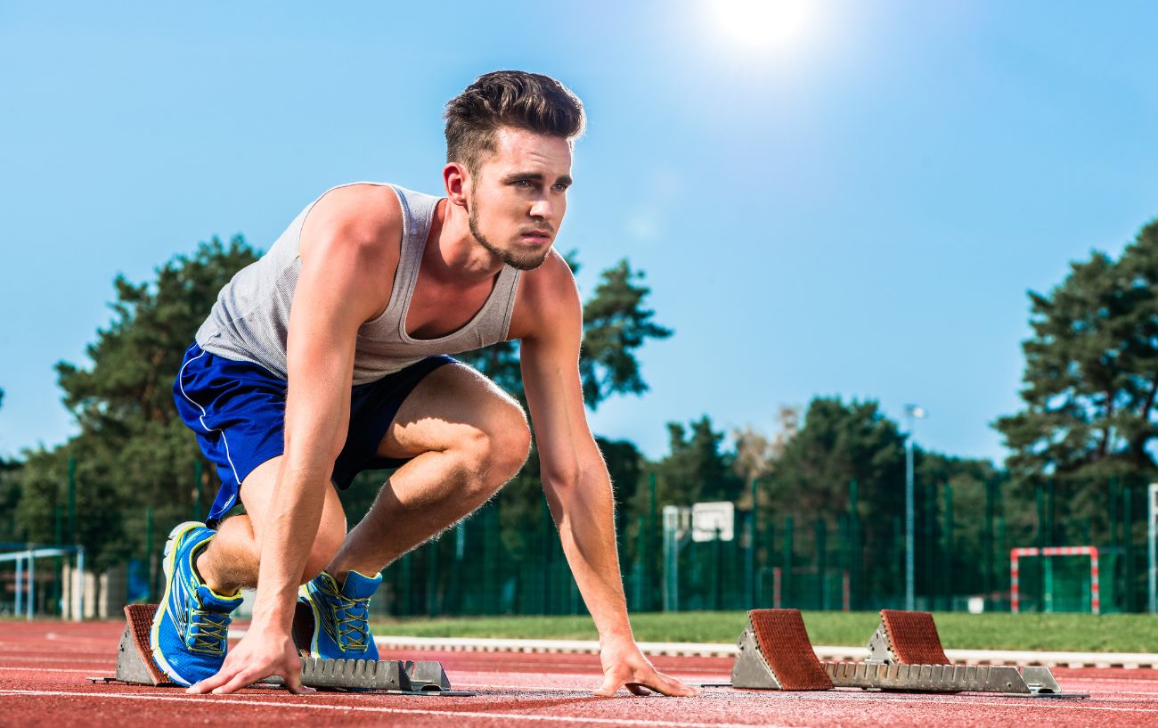 A person getting ready to sprint on the track.