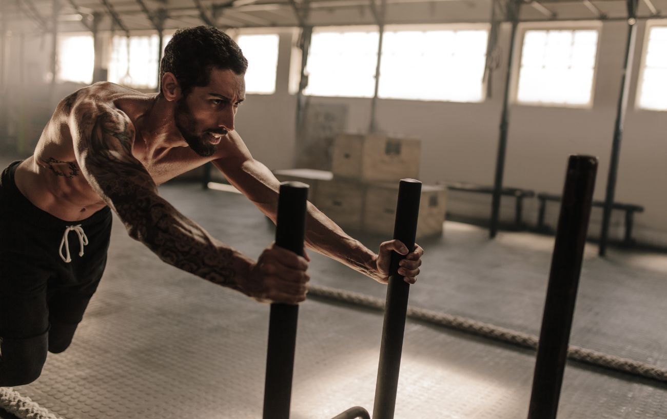 A person pushing a gym sled.