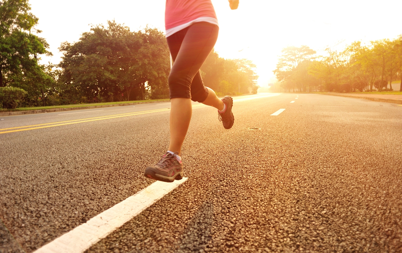 una mujer corriendo duro en la carretera