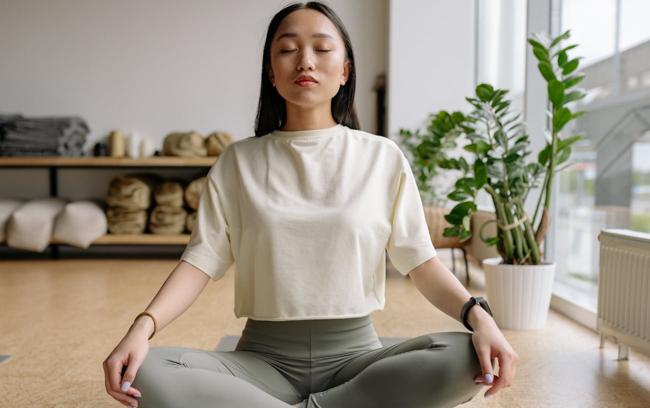 A person meditating in a studio.