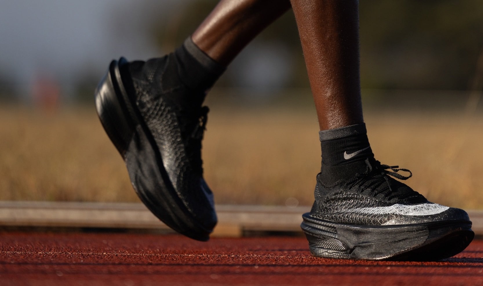 Jacob Kiplimo wearing black Nike Apex shoes on a red running track