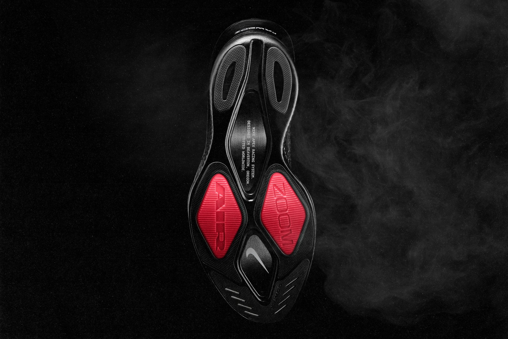 The Nike Apex outsole, with red Air Zoom pods under the forefoot, cutouts in the heel and the words Nike Apex Racing System printed on the midfoot